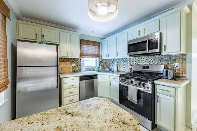 a kitchen with stainless steel appliances granite countertop a stove a refrigerator and a microwave