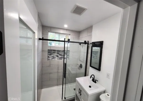 a bathroom with a shower a sink and a mirror