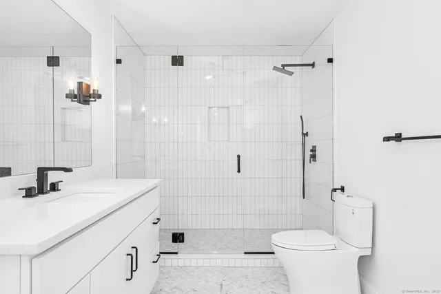 a bathroom with a sink toilet vanity and shower