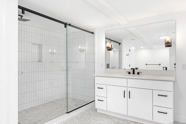 a bathroom with a shower sink and mirror