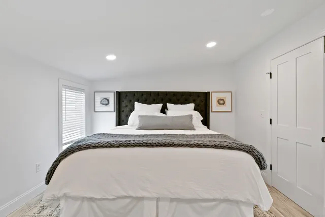 a bathroom with a granite countertop sink a large mirror a toilet and a window