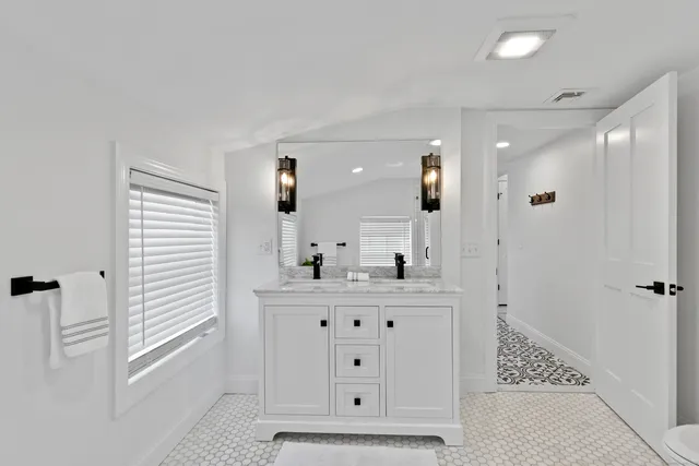 a bathroom with a granite countertop sink mirror and shower