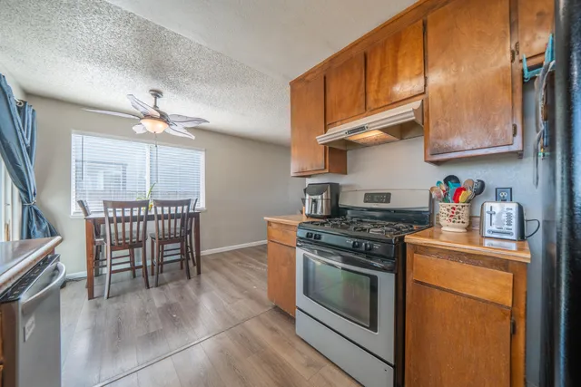 a kitchen with stainless steel appliances granite countertop a stove a chimney a sink and cabinets