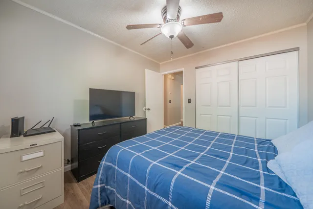 a bedroom with a bed and a flat tv screen on dresser