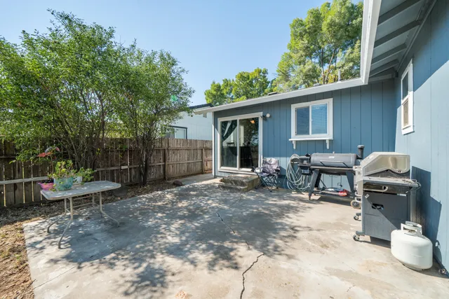 a view of a patio with table and chairs and wooden fence