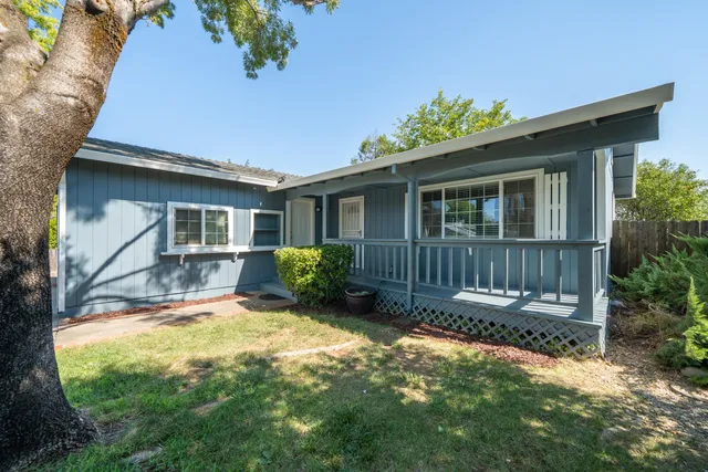 a view of a house with backyard and sitting area