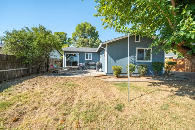 a view of a house with backyard and sitting area