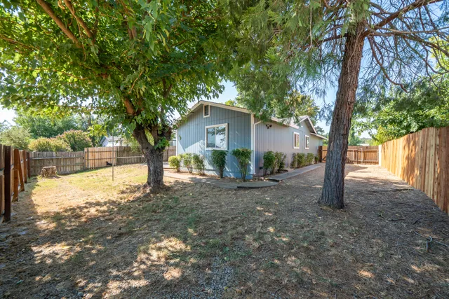 a view of a house with backyard and tree