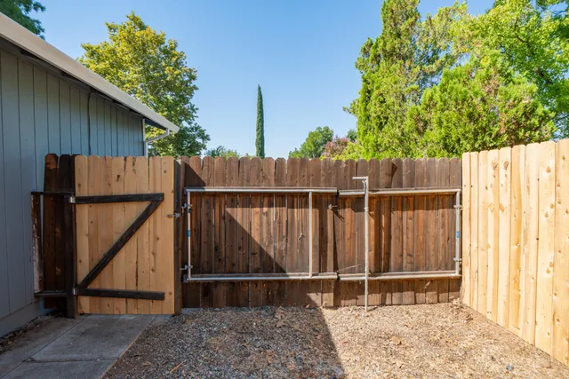 a backyard of a house with wooden fence