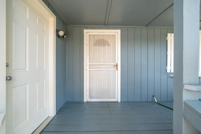 a view of an empty room with window and door