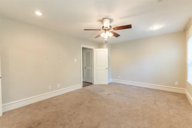 an empty room with a window and a fan