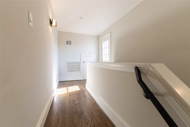 a view of hallway with wooden floor and stairs