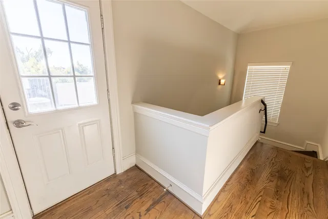 a view of a hallway with wooden floor and staircase