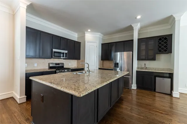 a kitchen with stainless steel appliances granite countertop a sink stove microwave and refrigerator