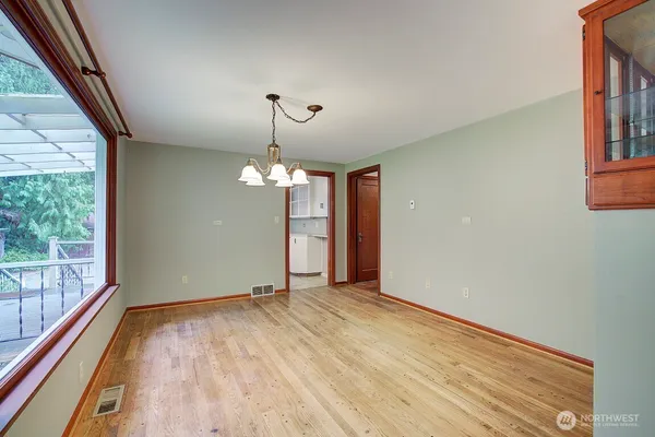 a view of a room with wooden floor chandelier and windows