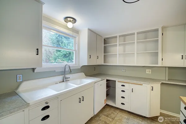 a kitchen with a sink cabinets and window