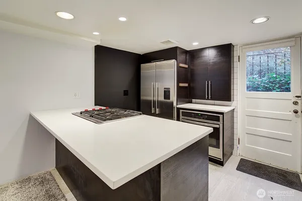 a kitchen that has a kitchen island wooden cabinets and stainless steel appliances