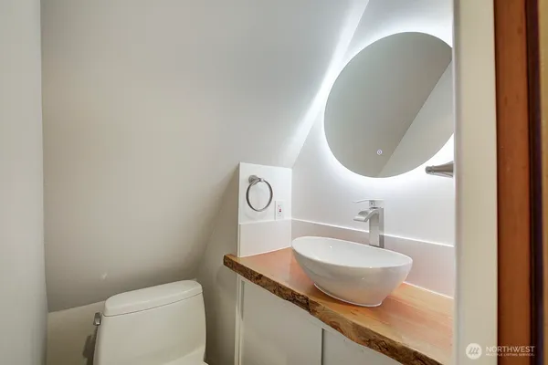 a bathroom with a granite countertop toilet a sink and mirror