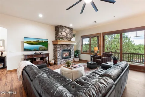 a living room with furniture kitchen view and a large window