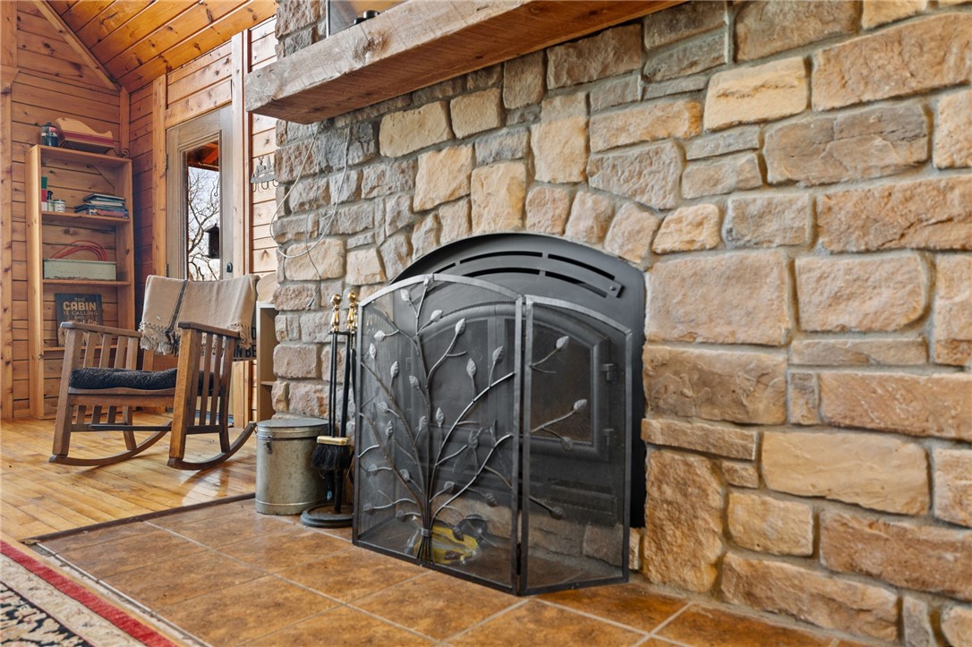 10557 North Devils Den Road Winslow, AR 72959 - Photo 8 of 60 Detailed view of a fireplace, wooden ceiling, and wooden walls