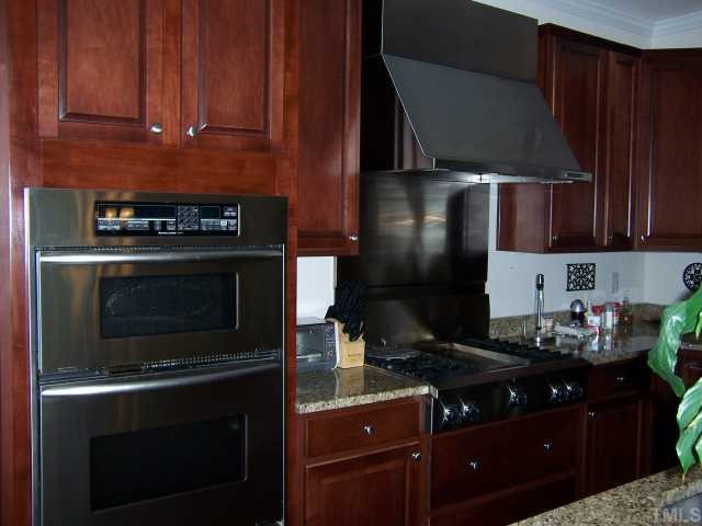 12708 Amoretto Way Raleigh, NC 27613 - Photo 6 of 12 Kitchen complete with stainless appliances, gas range, granite counter tops, wine chiller and island bar.