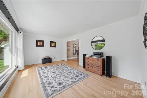 a view of a bedroom with wooden floor and window