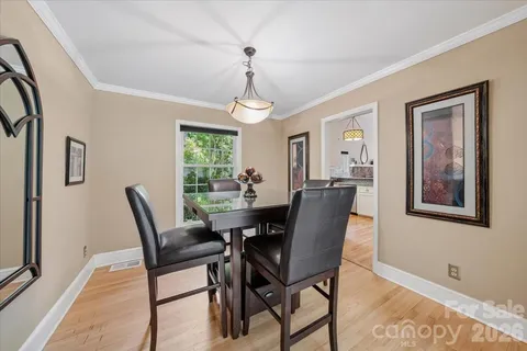 a dining room with furniture a chandelier and wooden floor