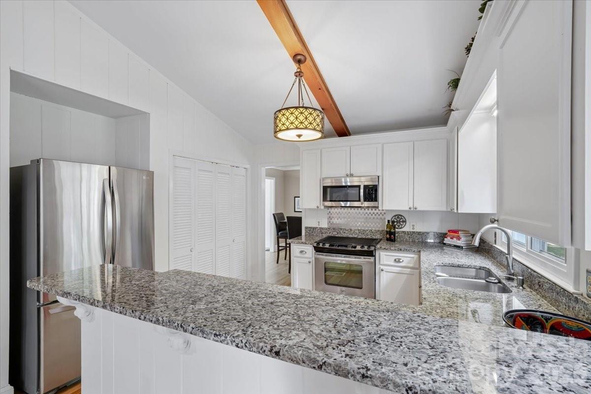 6701 Ronda Avenue Charlotte, NC 28211 - Photo 25 of 46 a kitchen with stainless steel appliances granite countertop a sink a stove and a refrigerator