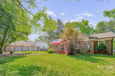 a front view of a house with a garden and trees