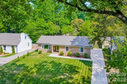 an aerial view of a house with a yard and outdoor seating