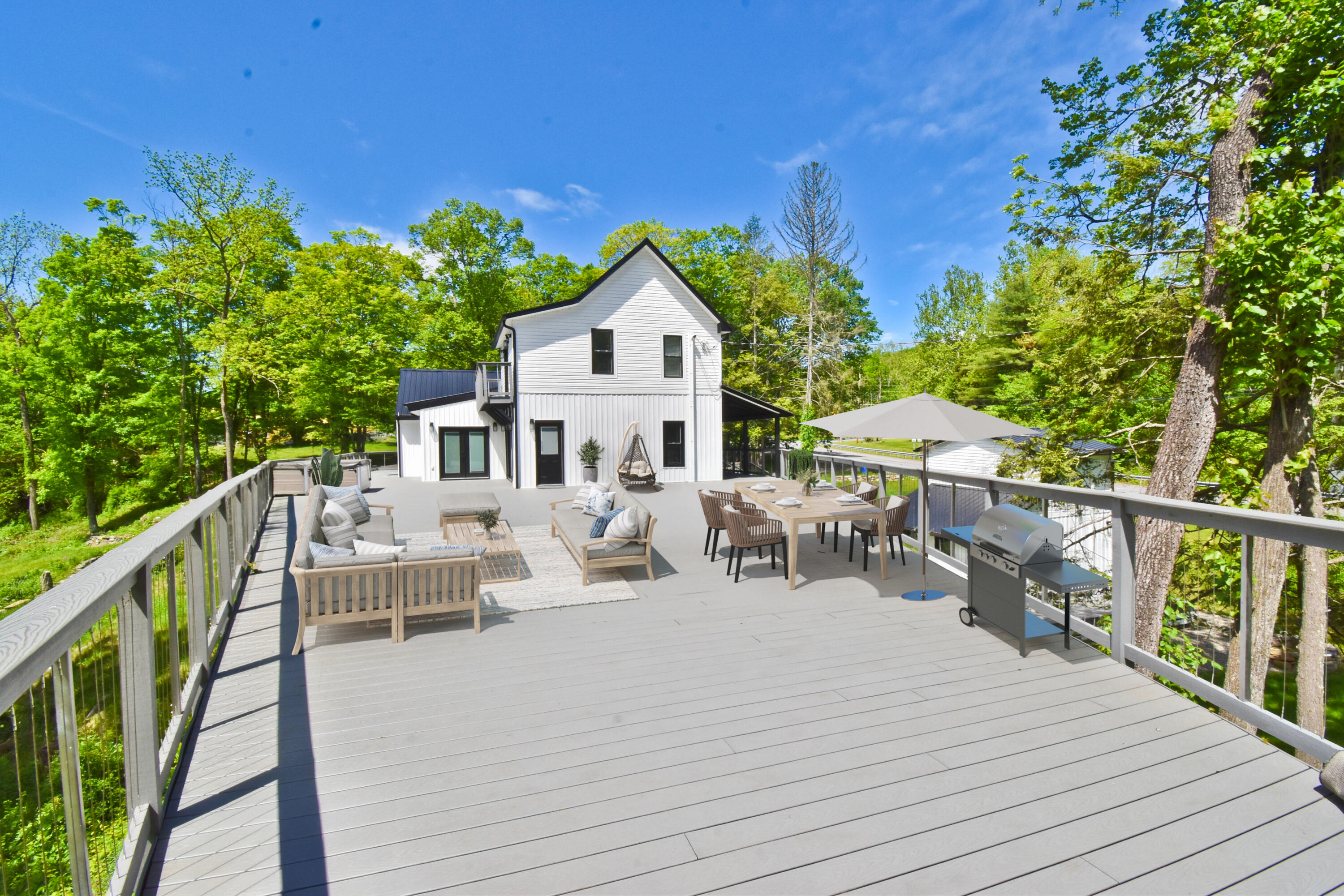 1104 Buttermilk Falls Road East Stroudsburg, PA 18301 - Photo 53 of 73 a view of house with deck outdoor seating and trees in the background