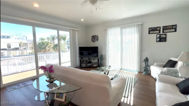a living room with furniture a flat screen tv and a large window
