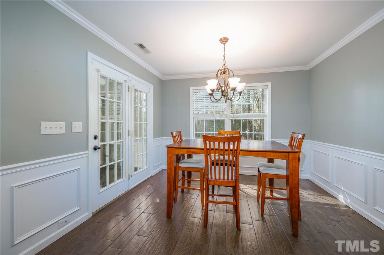 4520 Drewbridge Way Raleigh, NC 27604 - Photo 11 of 22 a view of a dining room with furniture a chandelier and wooden floor