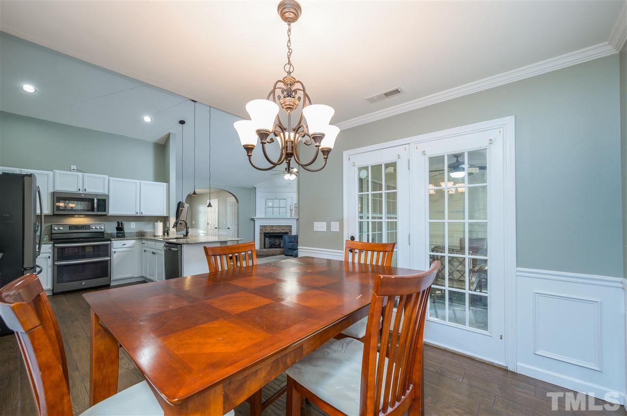 4520 Drewbridge Way Raleigh, NC 27604 - Photo 12 of 22 a view of a dining room with furniture a chandelier and wooden floor