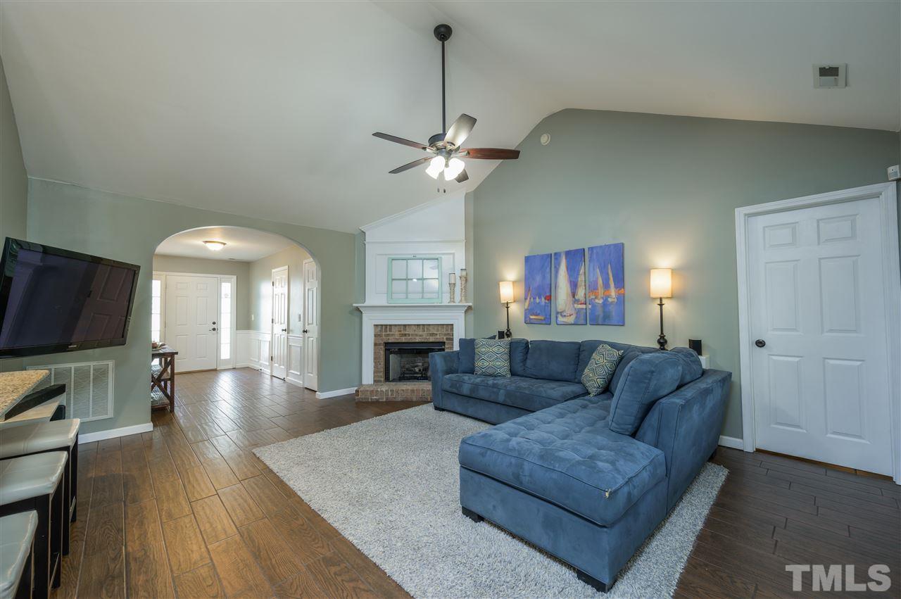 4520 Drewbridge Way Raleigh, NC 27604 - Photo 13 of 22 a living room with furniture a fireplace and a flat screen tv