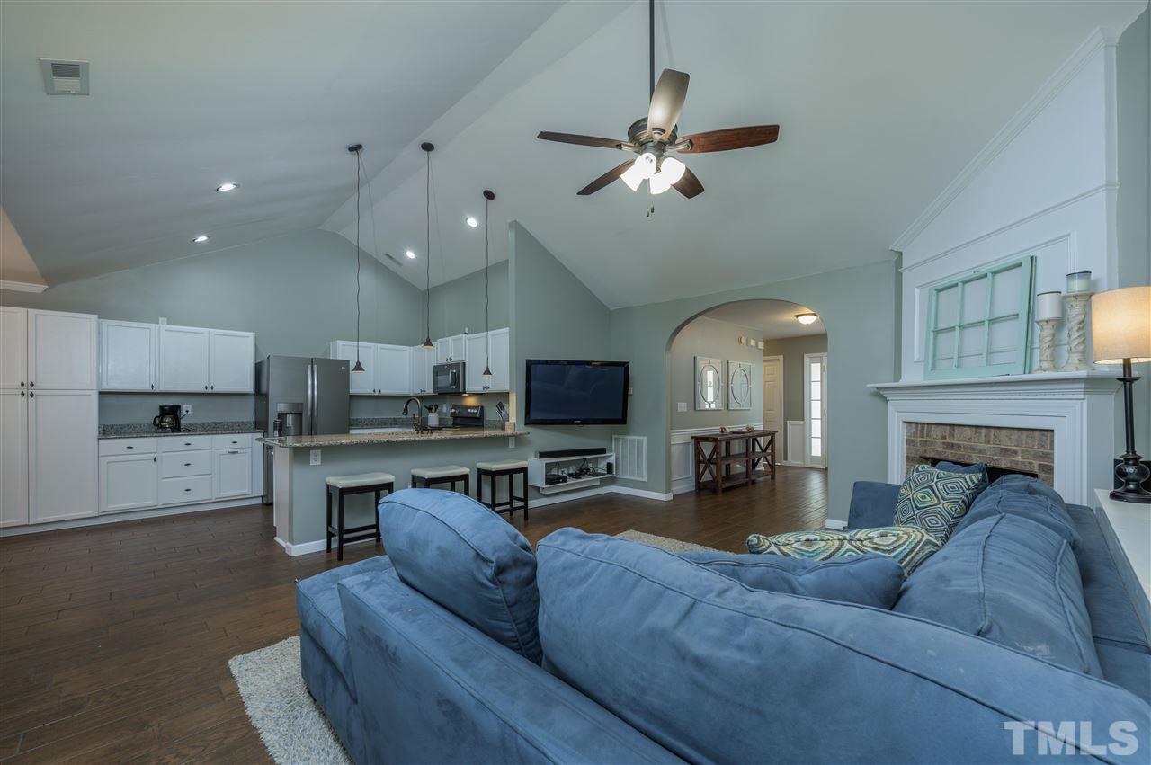 4520 Drewbridge Way Raleigh, NC 27604 - Photo 14 of 22 a living room with furniture a fireplace and a flat screen tv