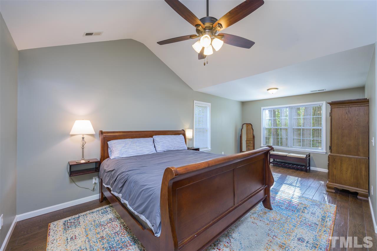 4520 Drewbridge Way Raleigh, NC 27604 - Photo 15 of 22 a bedroom with a large bed and a chandelier