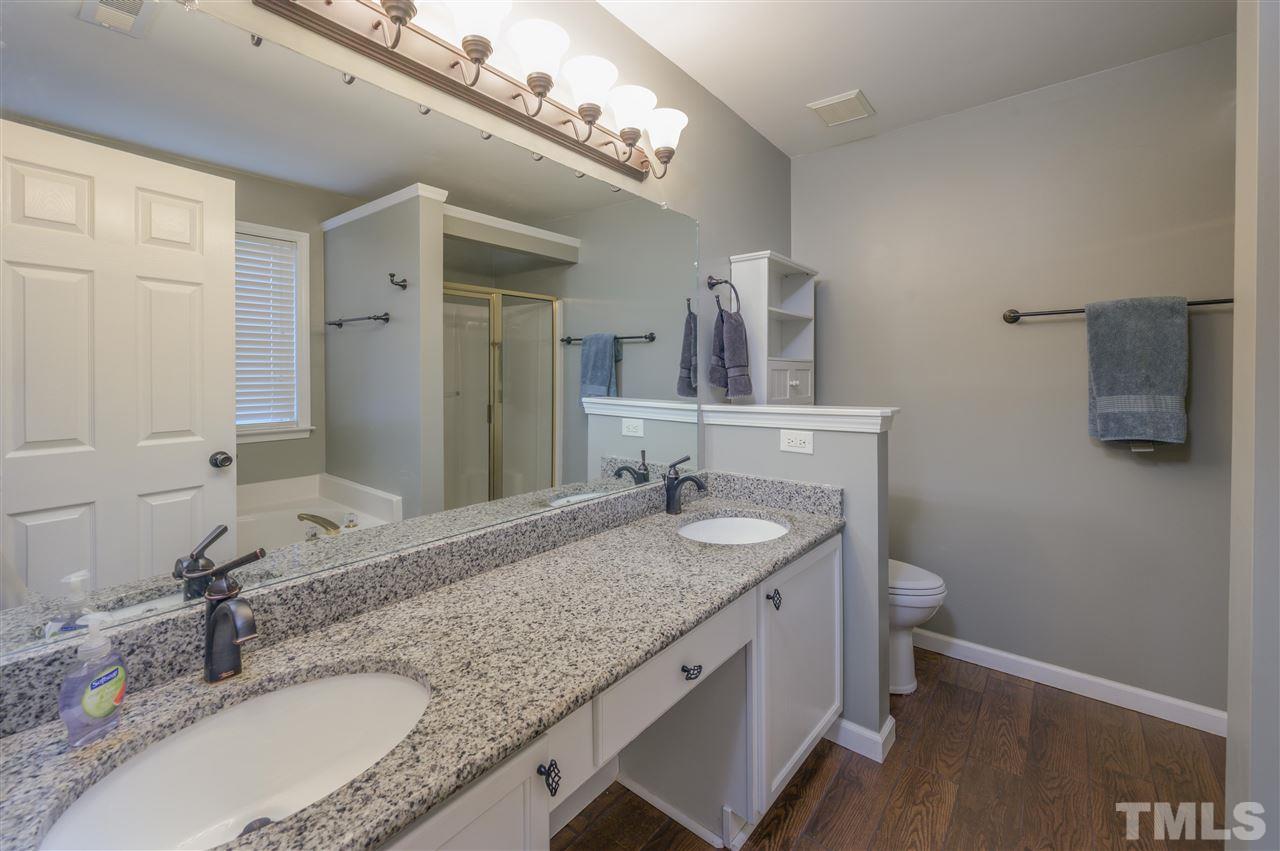 4520 Drewbridge Way Raleigh, NC 27604 - Photo 16 of 22 a bathroom with a granite countertop double vanity and a mirror