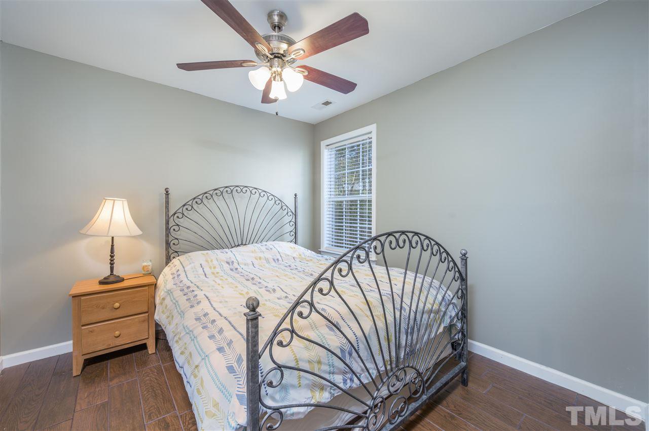 4520 Drewbridge Way Raleigh, NC 27604 - Photo 17 of 22 a bedroom with a bed and a chandelier