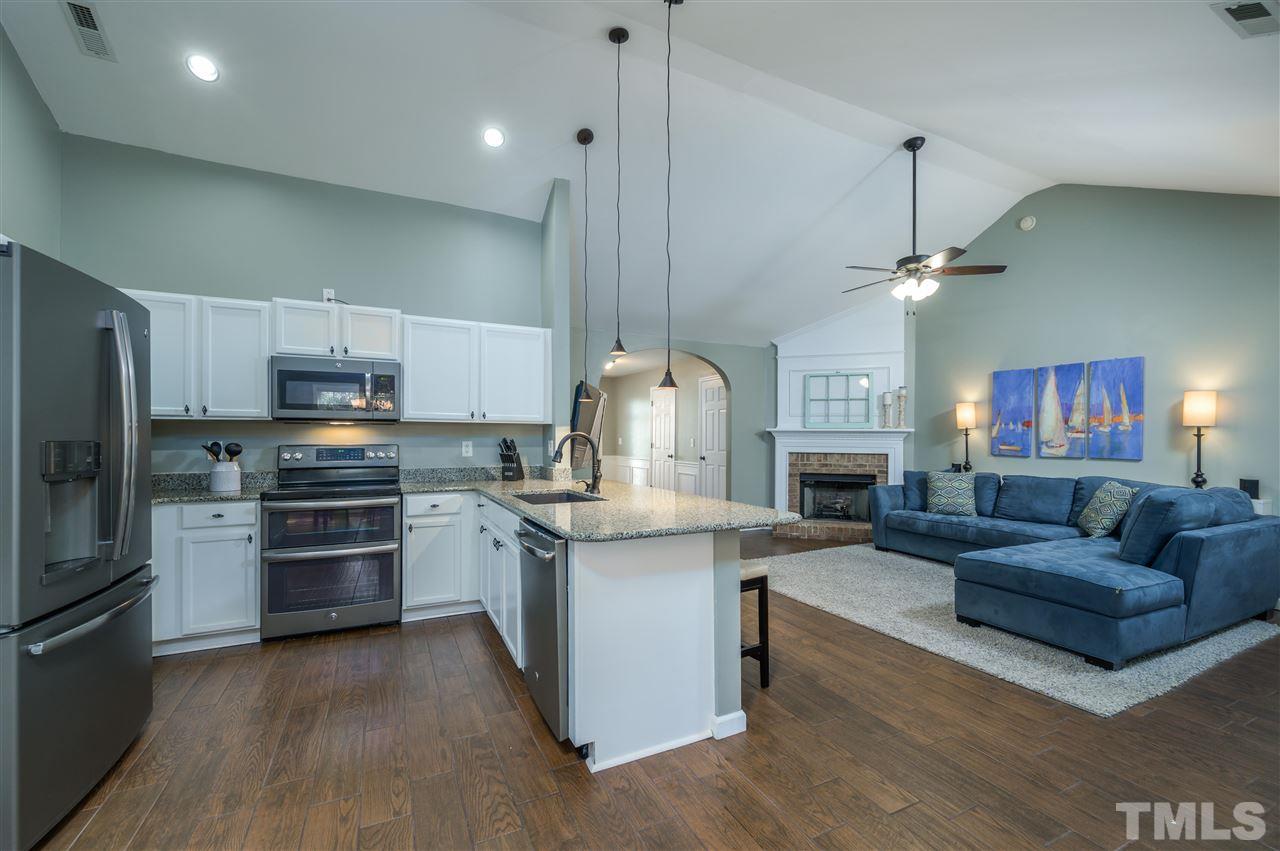4520 Drewbridge Way Raleigh, NC 27604 - Photo 8 of 22 a living room with stainless steel appliances furniture a kitchen island a stove and a refrigerator