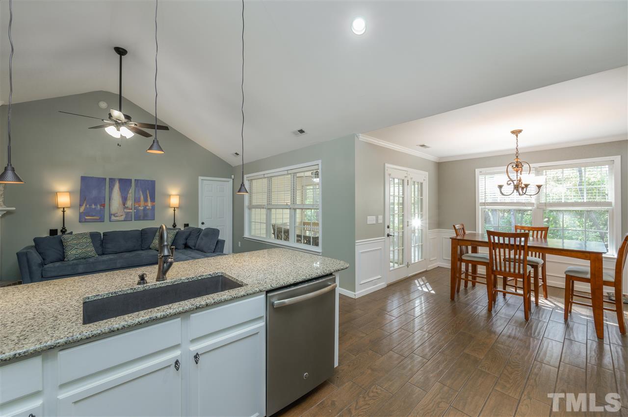 4520 Drewbridge Way Raleigh, NC 27604 - Photo 10 of 22 a open kitchen with stainless steel appliances granite countertop a sink dishwasher a dining table and chairs with wooden floor