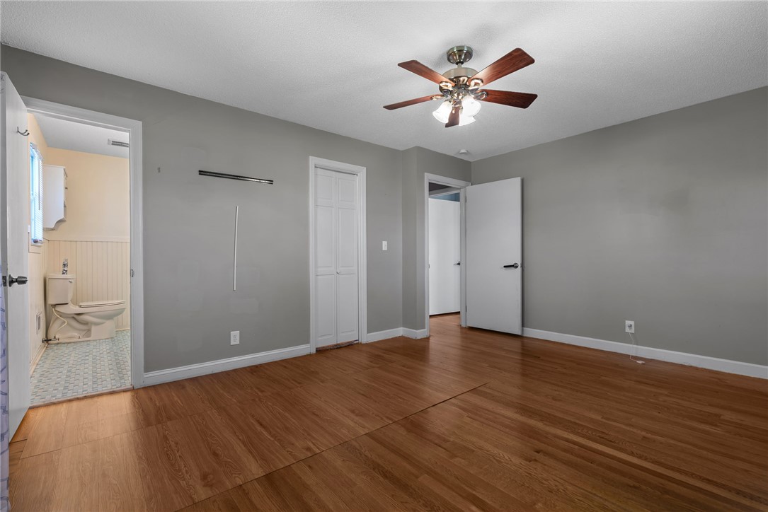 300 Green Street Williamston, SC 29697 - Photo 14 of 47 This inviting bedroom features rich hardwood flooring and a ceiling fan, offering comfortable living.