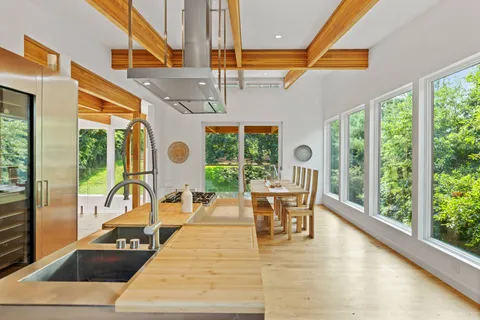 a dining room with wooden floor table and chairs
