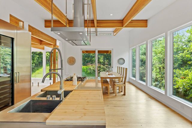 a dining room with wooden floor table and chairs