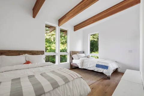 a bedroom with a bed lamp and a large window