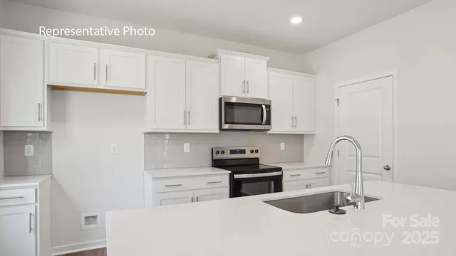 a kitchen with stainless steel appliances granite countertop a sink a stove and a microwave