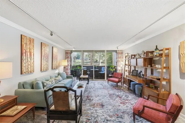 a living room with furniture a large window and bookshelf