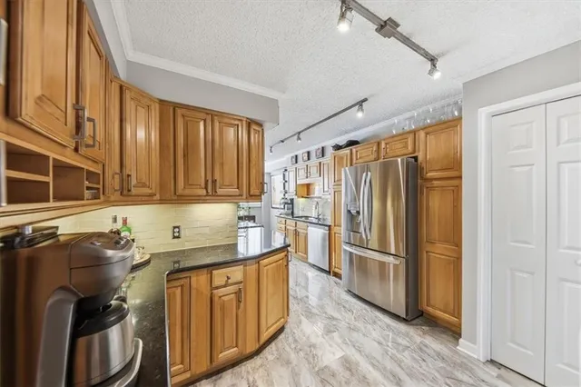 a kitchen with stainless steel appliances granite countertop a refrigerator and a sink