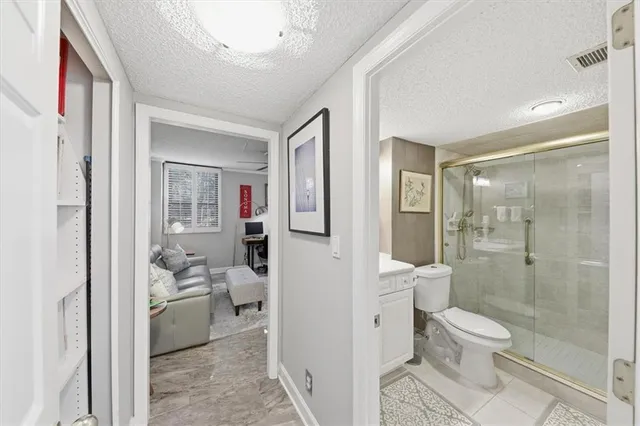 a bathroom with a toilet shower vanity and a sink