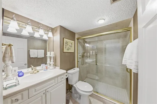 a bathroom with a shower sink vanity mirror and toilet